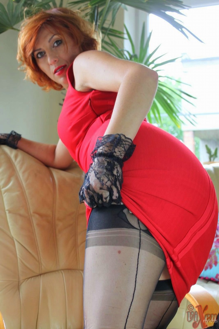 Hot redhead Vixen Nylons hikes up her red dress in sexy hose and garter attire foto porno #428633079