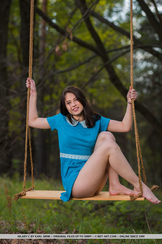 Young brunette Hilary C is encouraged to get naked on swing set in forest foto porno #425338912
