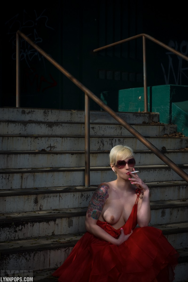 Tattooed Blonde Lynn Pops Smokes While Letting Her Boobs Free Of A Red Dress