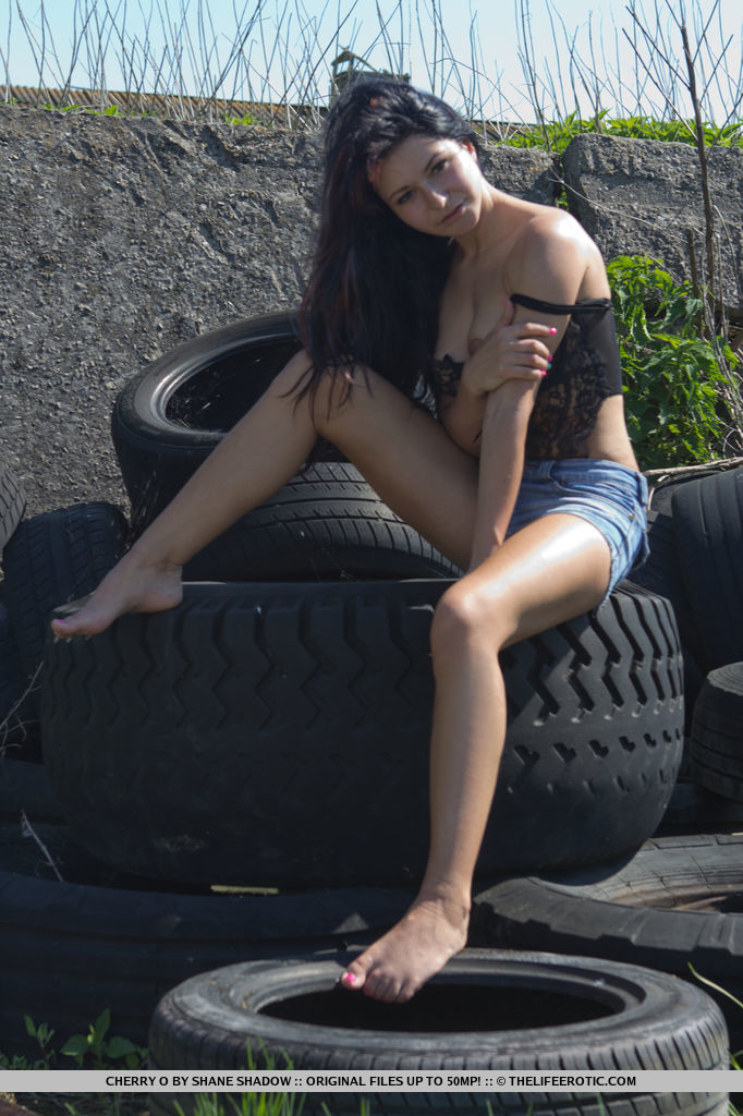 Brunette teen Cherry O fingers her cunt after getting naked on used tires foto porno #425290406