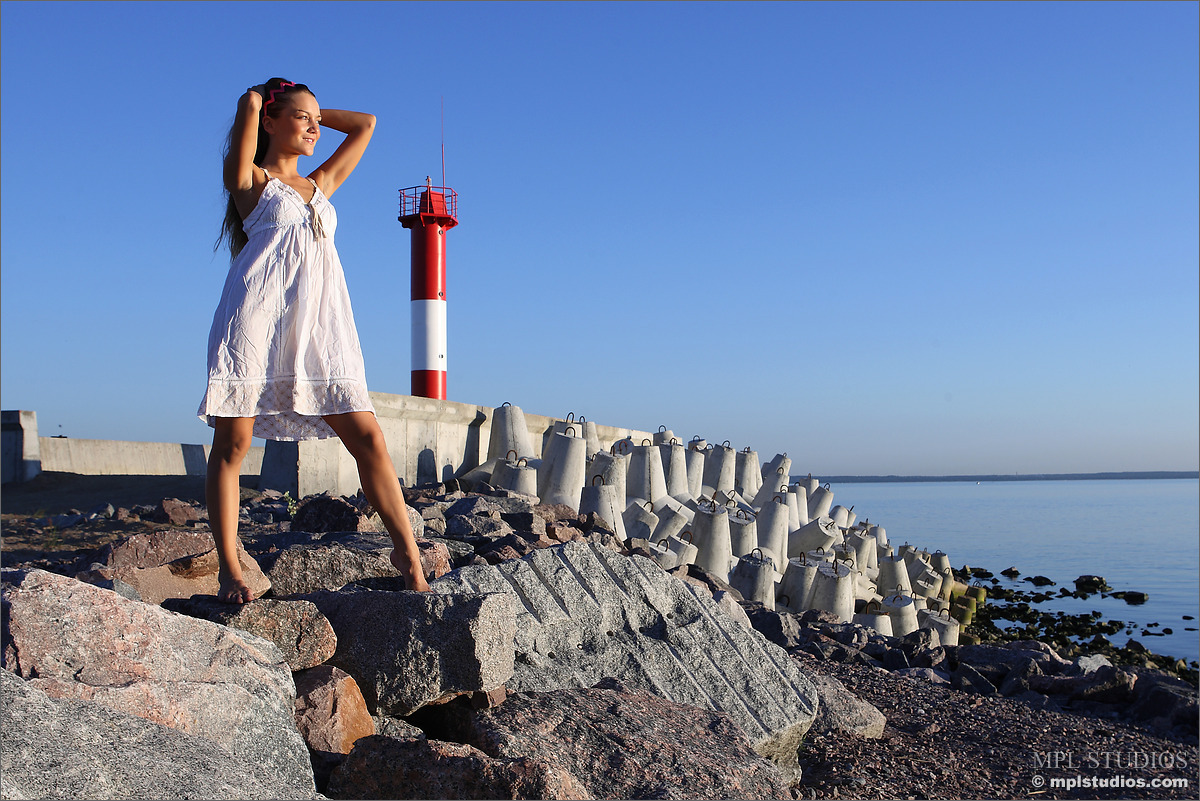 Teen model gets completely naked on rocks near a lighthouse porn photo #425337494
