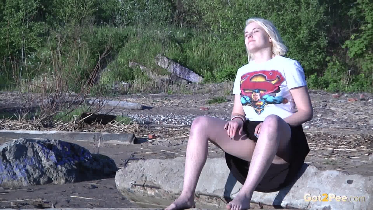 Leggy blonde Nura sits down for a piss on driftwood at the beach porn photo #428794702