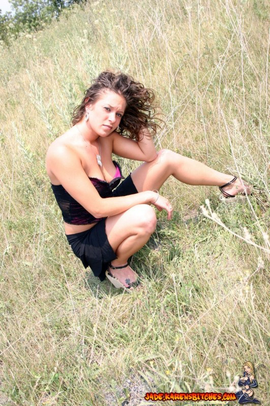 Teen amateur shows some cleavage during a SFW shoot out in a field