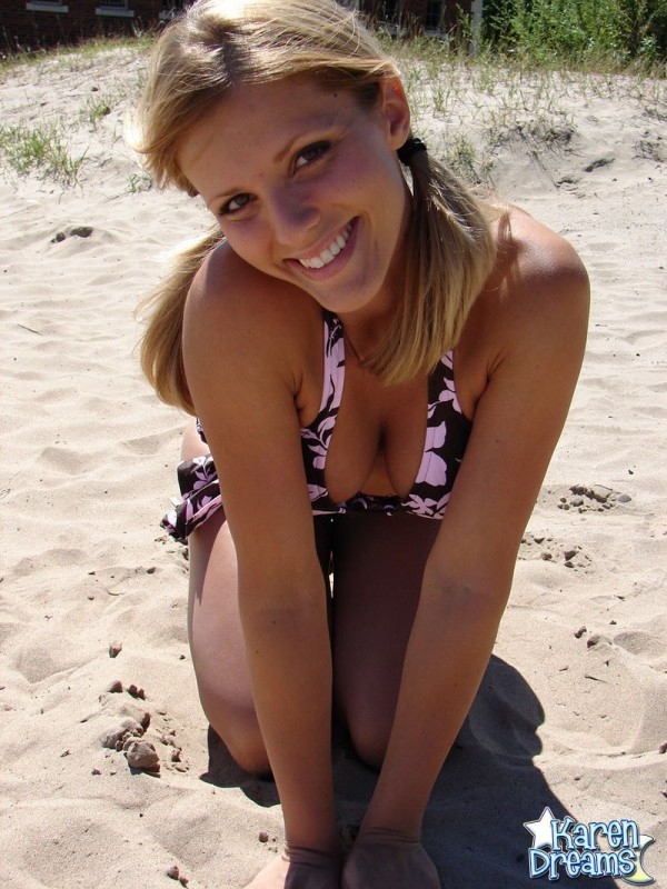 Sexy Karen models a bikini on the beach in an area of sand.