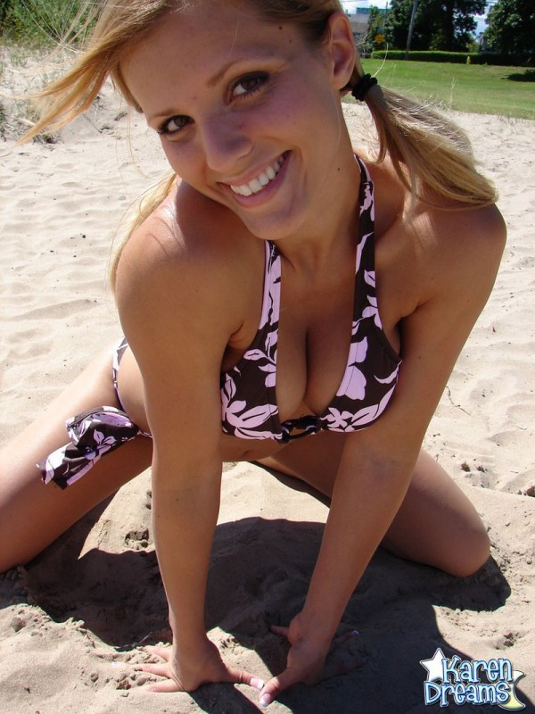 On a patch of sand, Karen is seen wearing her tee and modeling in a bikini.