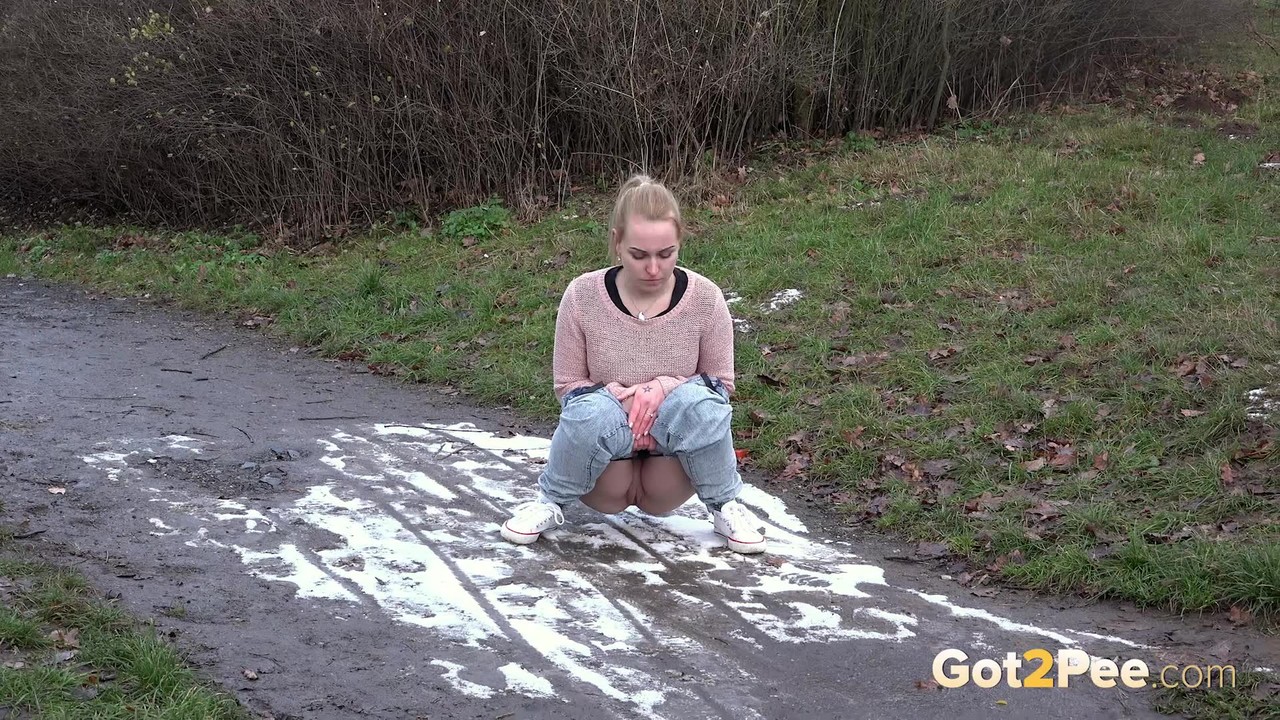Clothed Girl Pulls Down Her Pants To Pee In A Muddy Puddle On A Path