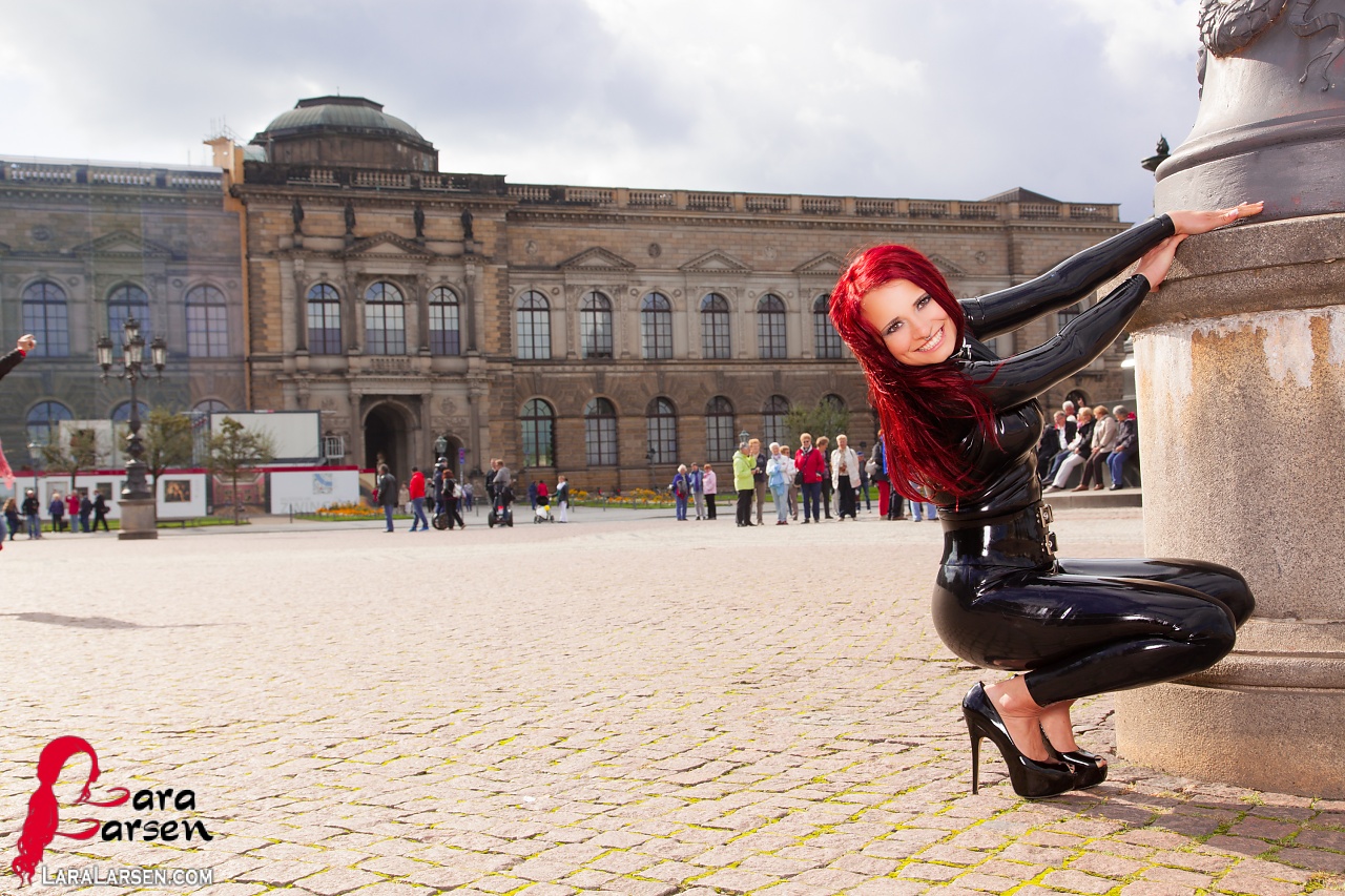 Solo model Lara Larsen sports red hair while modelling latex wear in a square ポルノ写真 #425304023