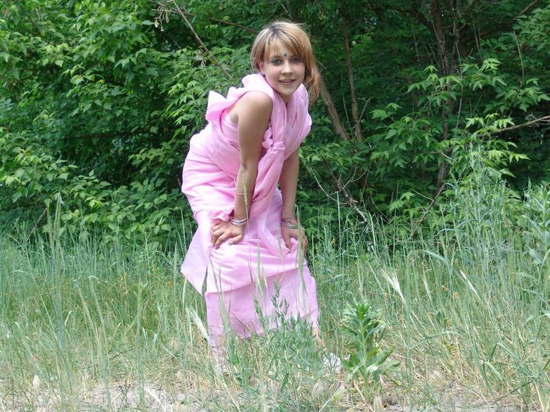 Teen first timer Liza gets naked in a field in front of a tree line