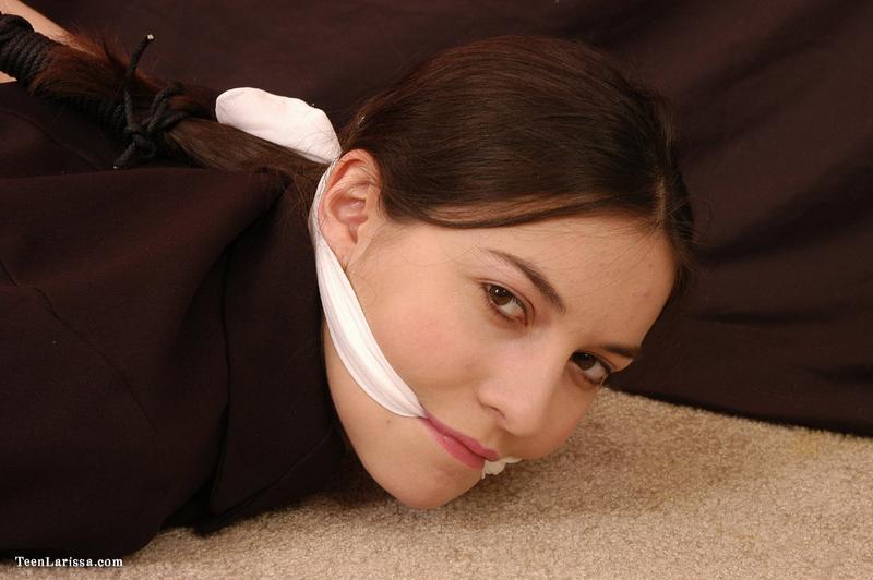 Brunette teen is hogtied in her clothing while sporting a cleave gag