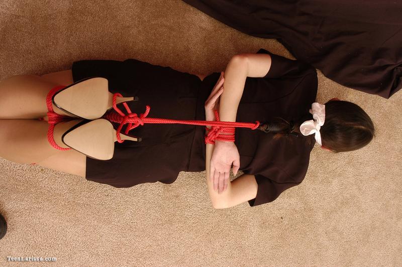 Brunette teen is hogtied in her clothing while sporting a cleave gag