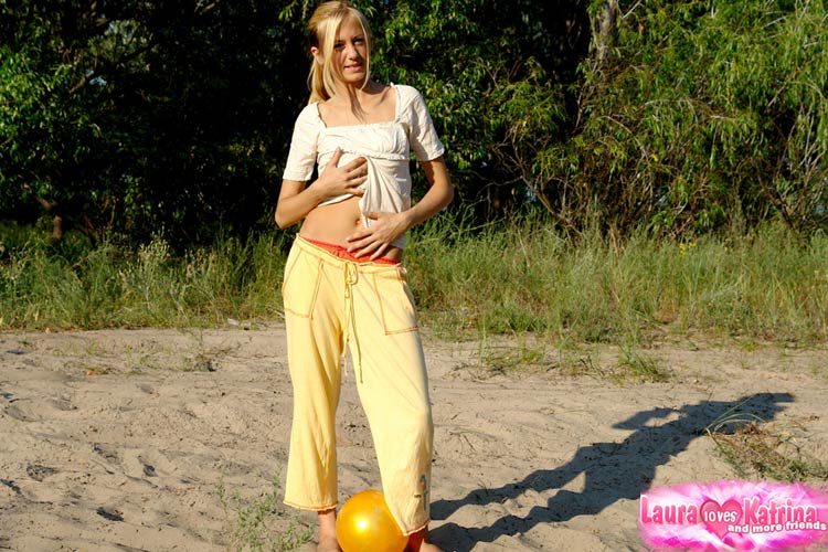Young blonde reveals her firm boobs as she disrobes outdoors