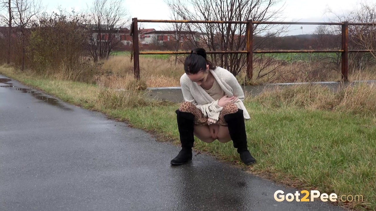 Short taken girl Eveline Neill pees on a paved path on a wet and dreary day foto porno #425647962