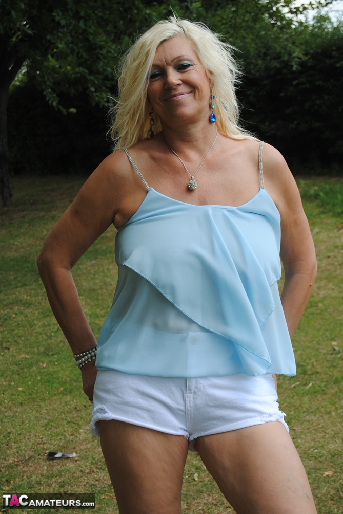 Hot mature Platinum Blonde spreading legs in shorts on blanket under the trees foto porno #425571284