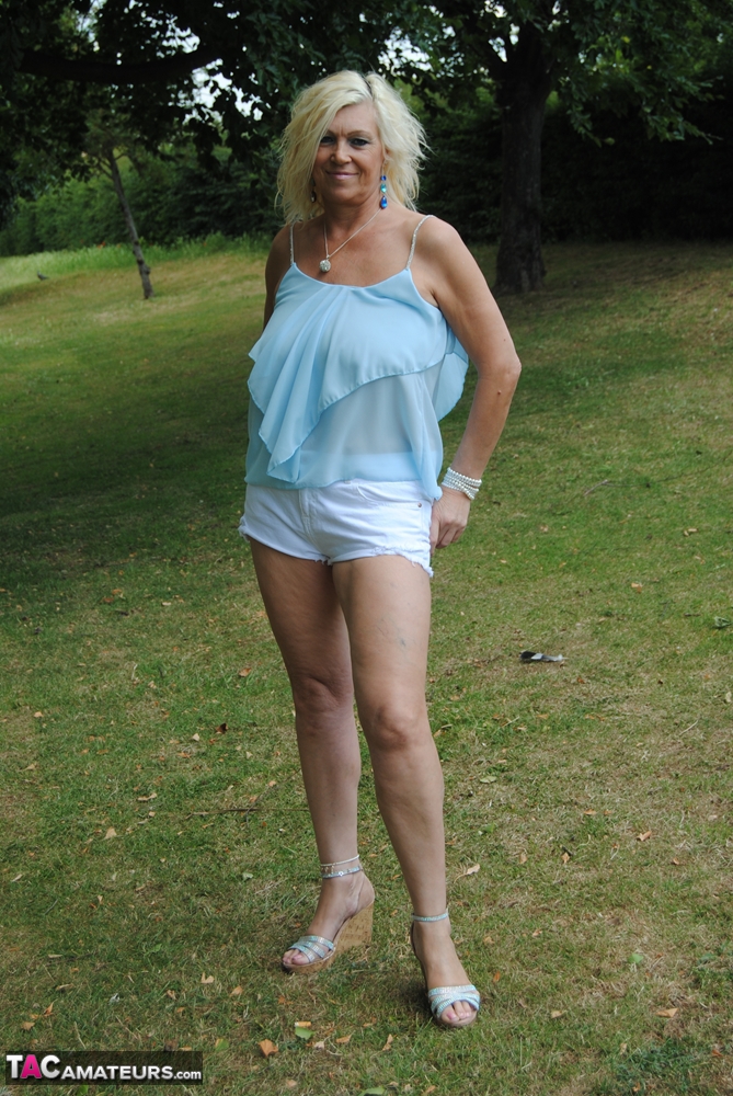 Hot mature Platinum Blonde spreading legs in shorts on blanket under the trees foto porno #425571286