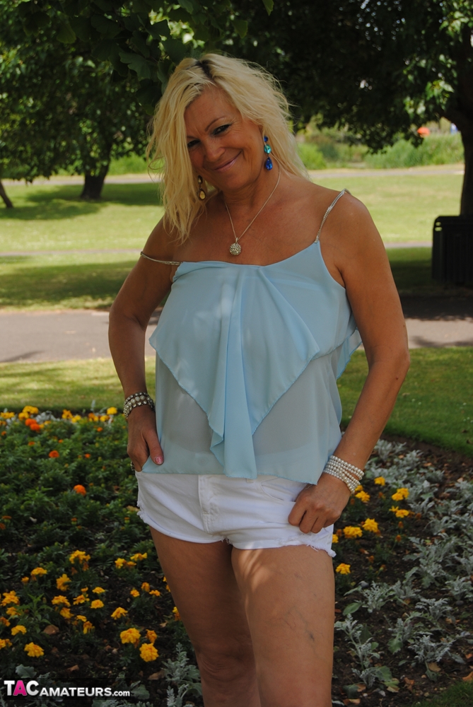 Hot mature Platinum Blonde spreading legs in shorts on blanket under the trees porn photo #425571292