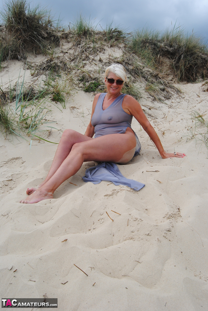 Beautiful busty mature Dimonty poses fully clothed in sheer dress at the beach porn photo #422585054