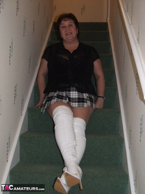 Mature BBW Kinky Carol gets naked in her underthings and OTK boots on stairs