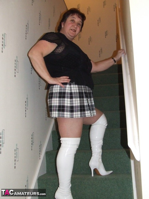 Mature BBW Kinky Carol gets naked in her underthings and OTK boots on stairs