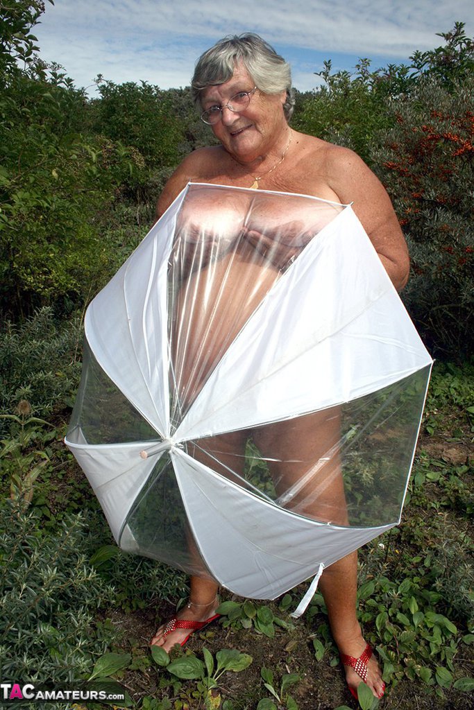 Obese oma Grandma Libby holds an umbrella while posing naked by fir trees foto porno #428543513