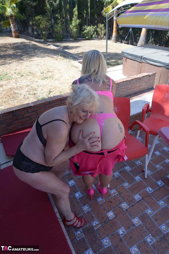 Older lesbian strips her busty blonde lover naked on shaded patio порно фото #427254192