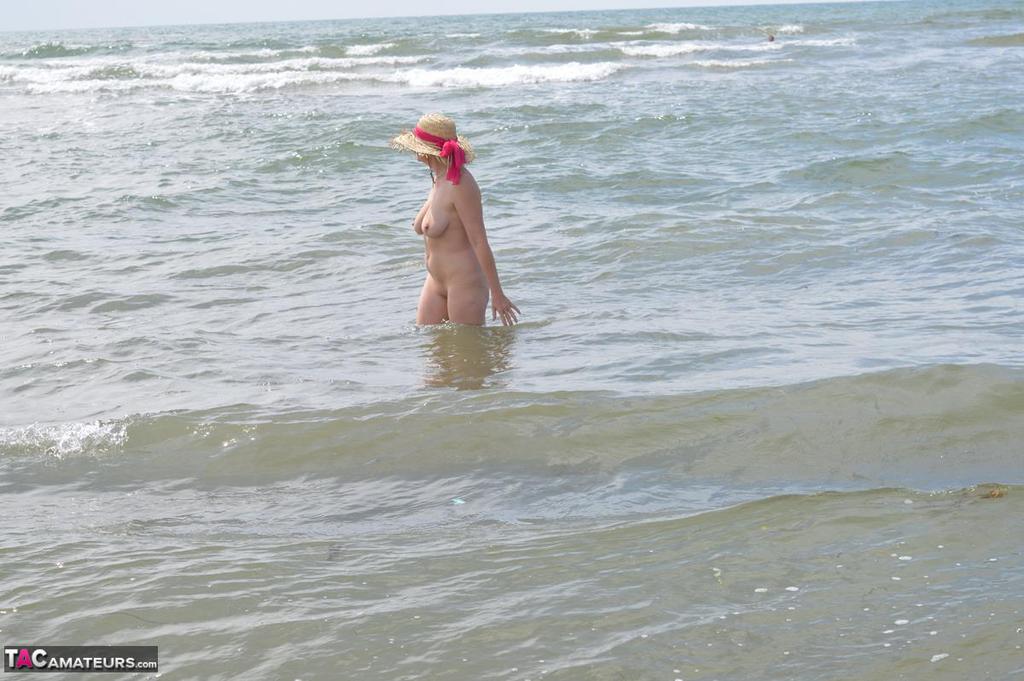 Wearing only a sun hat, Barby Slut, an older ex-parasite, ventures into the ocean.