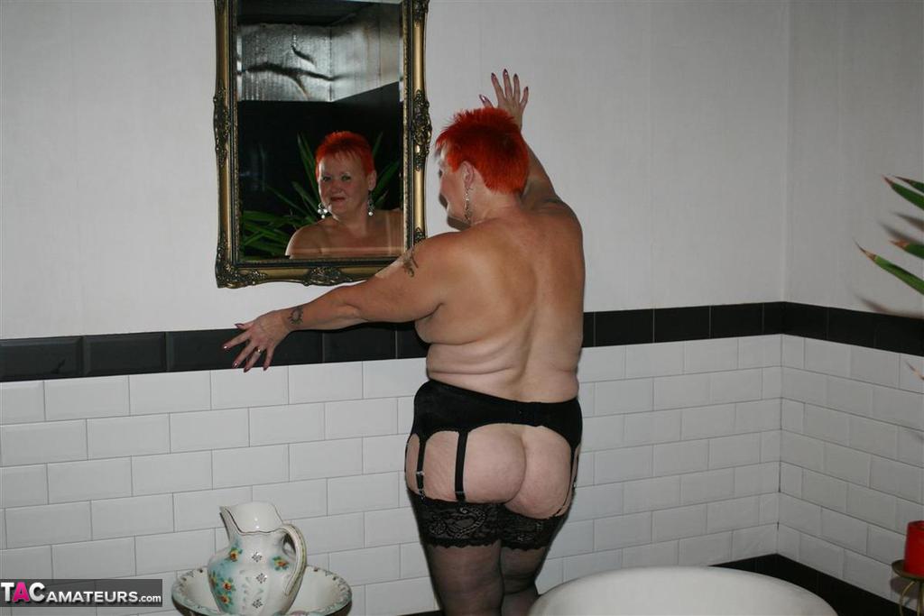 Older redhead Valgasmic Exposed models on the side of a claw tub in hosiery porn photo #425430149