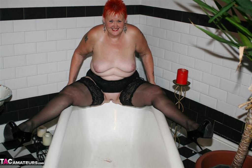 Older redhead Valgasmic Exposed models on the side of a claw tub in hosiery porn photo #425430178