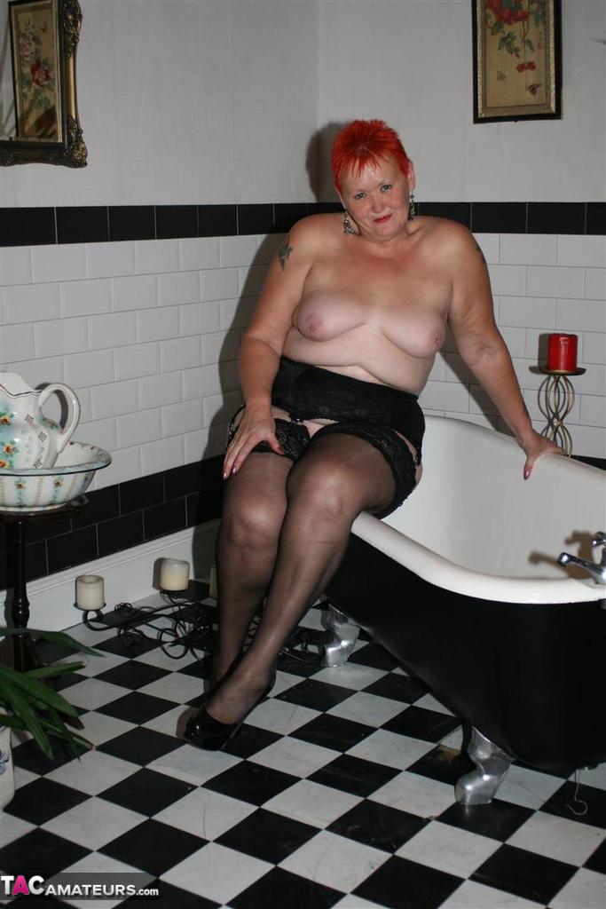 Older redhead Valgasmic Exposed models on the side of a claw tub in hosiery porno foto #425430181