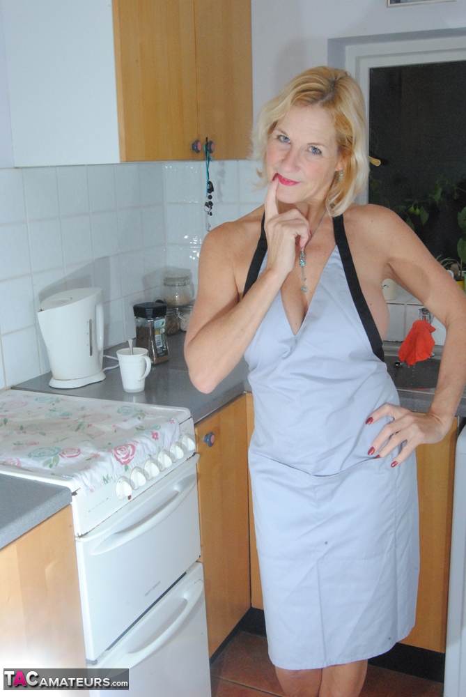 Mature MILF with blonde hair wears only an apron while devouring a banana porn photo #422530021
