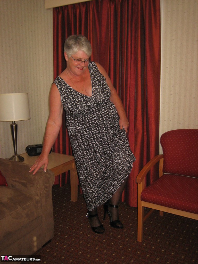 A fat granny Girdle Goddess wears a black slip and girdle with her no panty upskirt.