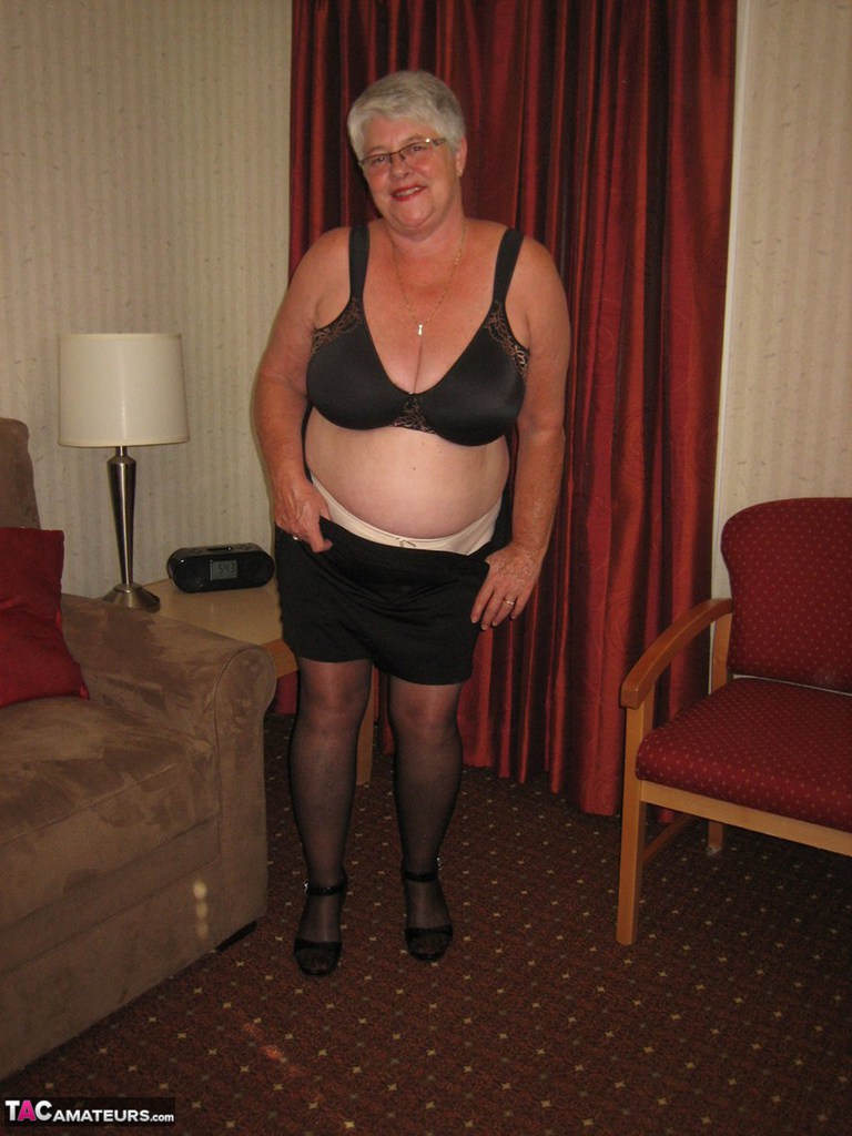 Fat Granny Girdle Goddess dons a black slip and coverall with an upskirt that is not pantomized.