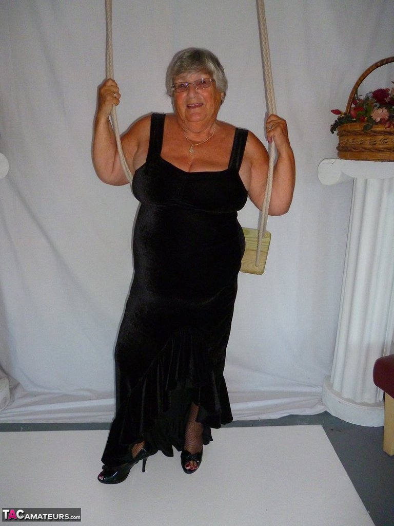 Modeling naked in stockings, Grandma Libby removes her clothing from a black dress.