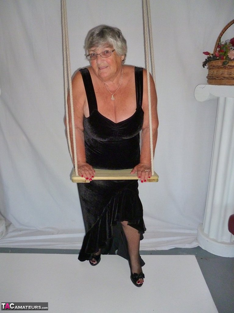 Taking off her black dress and modeling in stockings, Grandma Libby looks fat.