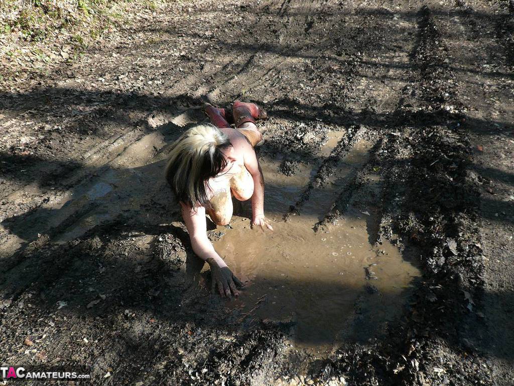 Older amateur Mary Bitch squats for a piss in a mud puddle while in the woods porn photo #424878834