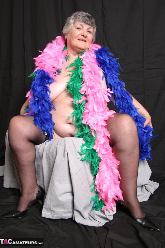 UK amateur Grandma Libby, who is fat and shows her big tits while wearing feather boas.