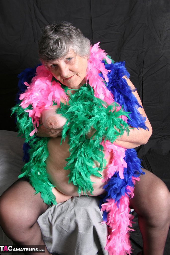 The Big Tits: Fat UK amateur Grandma Libby, who is dressed in feather boas, shows off her big tits.