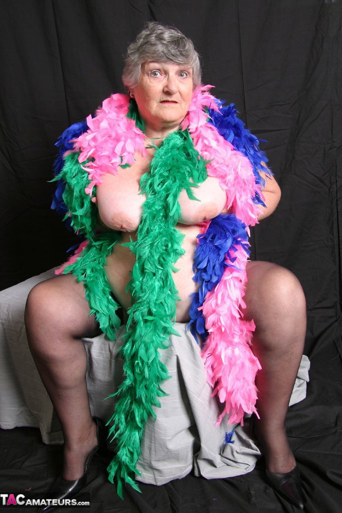 In the UK, Grandma Libby, who is fat and amateur, displays her large breasts with feathered boas to show off her big tits.