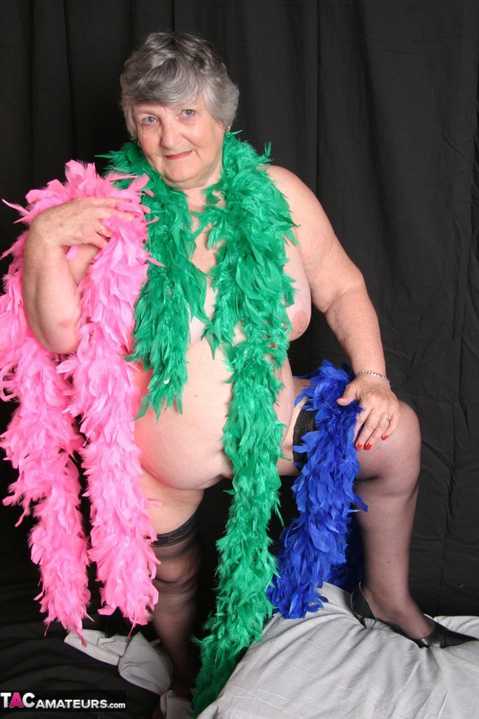 While wearing feather boas, overweight UK amateur grandma Libby flaunts her large thighs.