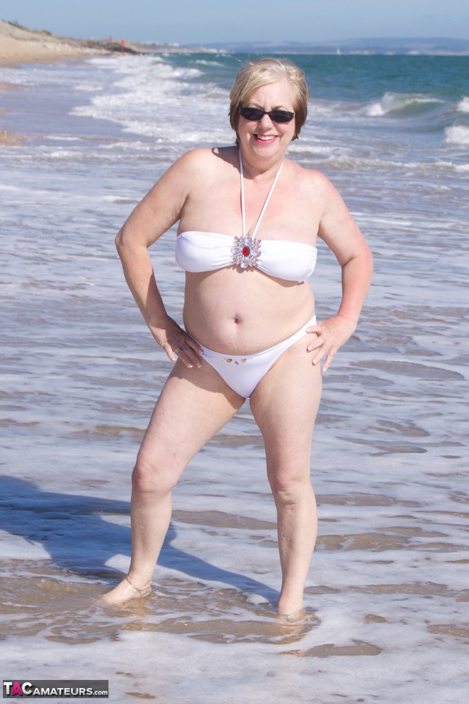 Mature amateur Speedy Bee gets naked in shades on a British beach foto porno #424794975