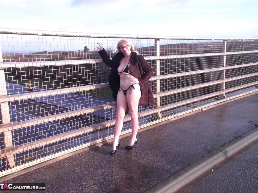 During an overpass, Barby Slut, an older performer, flashes on the sidewalk.
