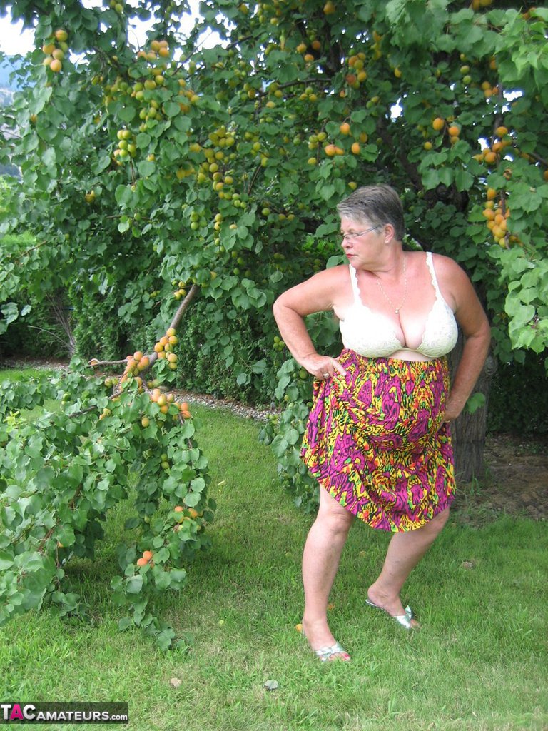 Fat granny Girdle Goddess exposes her large tits under a fruit bearing tree foto porno #425915574