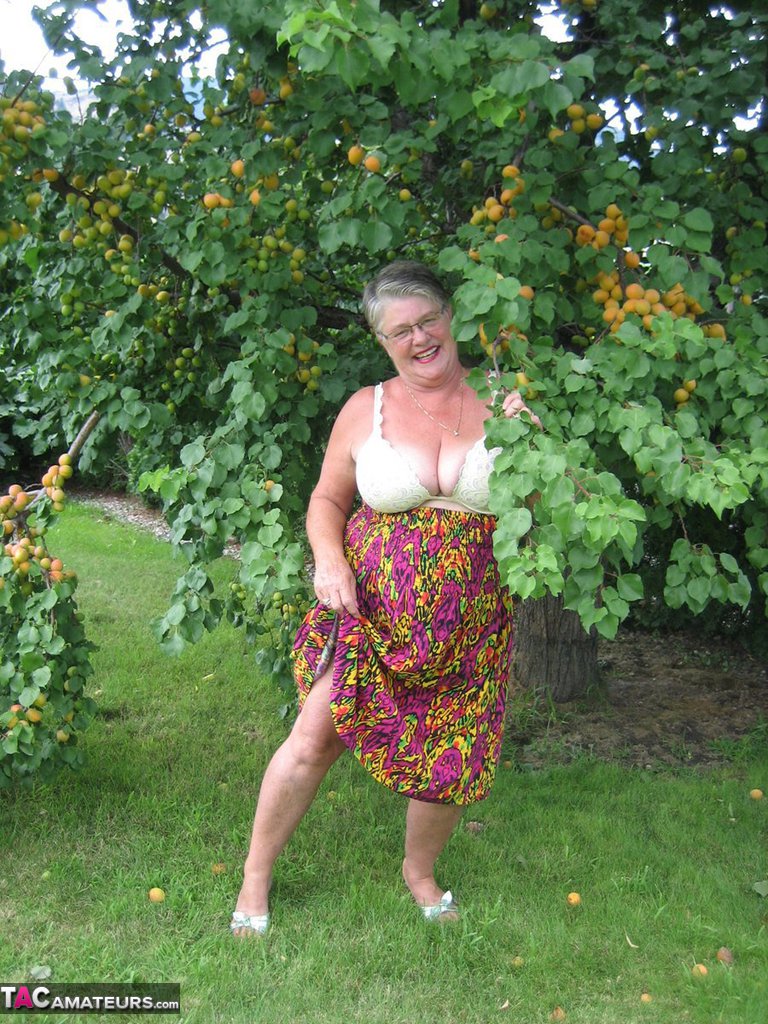 Fat granny Girdle Goddess exposes her large tits under a fruit bearing tree foto porno #425915576