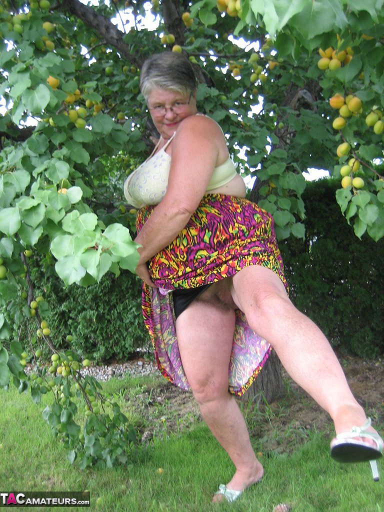 Fat granny Girdle Goddess exposes her large tits under a fruit bearing tree foto porno #425915583