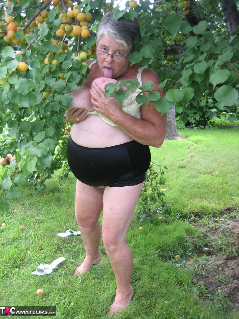 Fat granny Girdle Goddess exposes her large tits under a fruit bearing tree foto porno #425915608