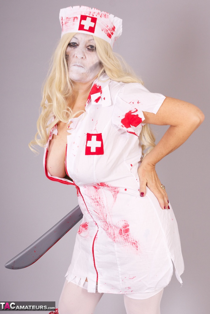 Old blonde amateur Savana removes a nurse uniform during a cosplay scene porn photo #428940171