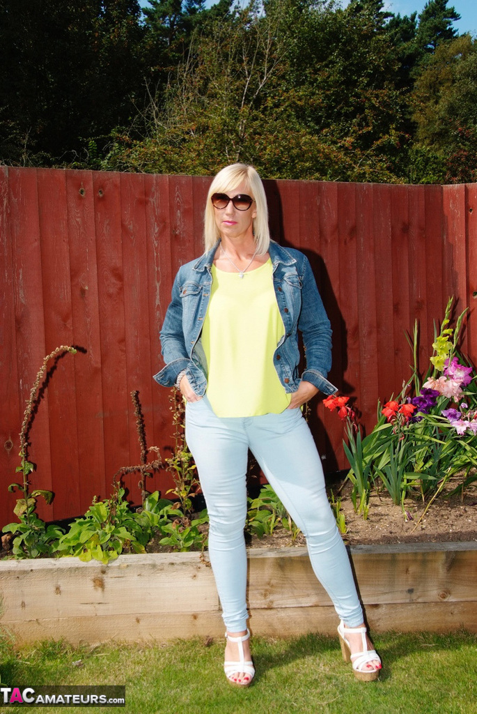 Middle-aged blonde Melody models in a bra and faded jeans in a backyard foto porno #428458784