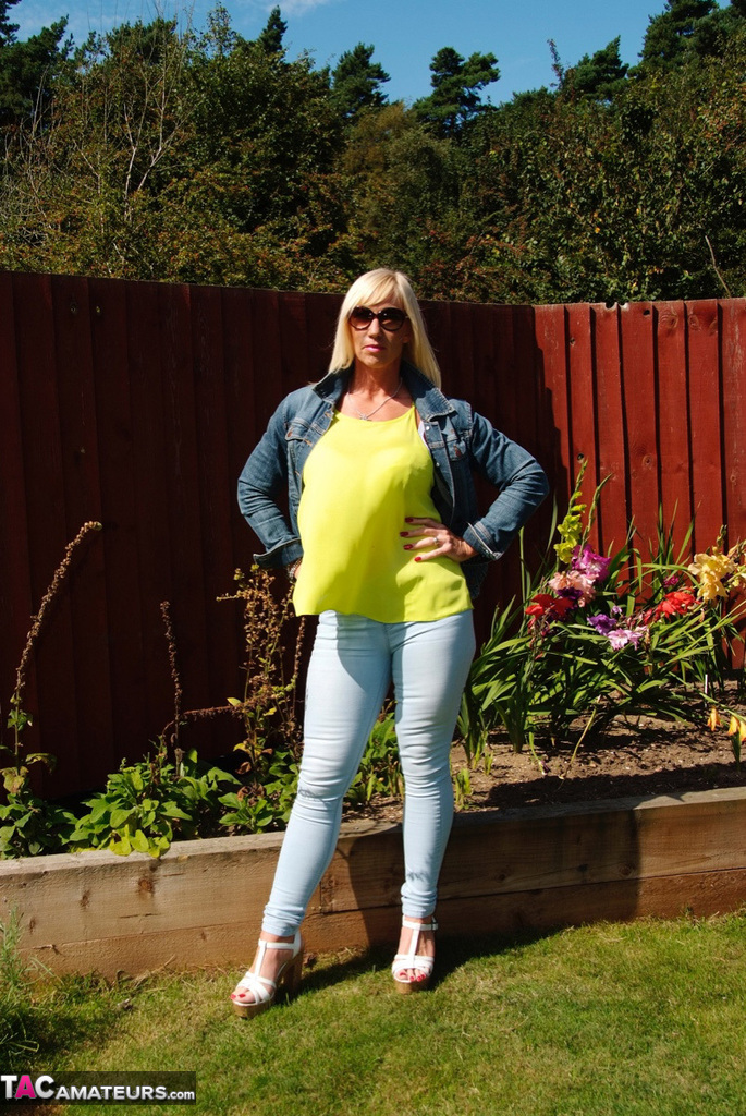 Middle-aged blonde Melody models in a bra and faded jeans in a backyard foto porno #428537058
