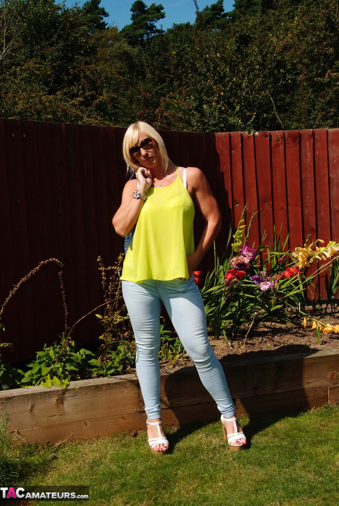 Middle-aged blonde Melody models in a bra and faded jeans in a backyard foto porno #428537063