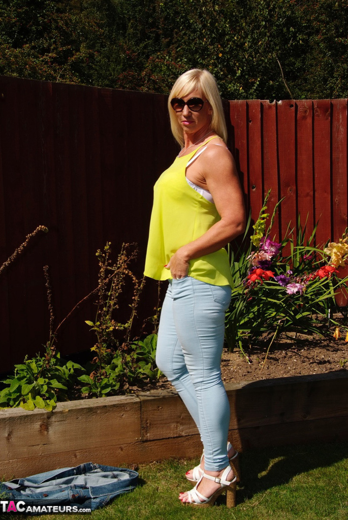 Middle-aged blonde Melody models in a bra and faded jeans in a backyard porno foto #428537066