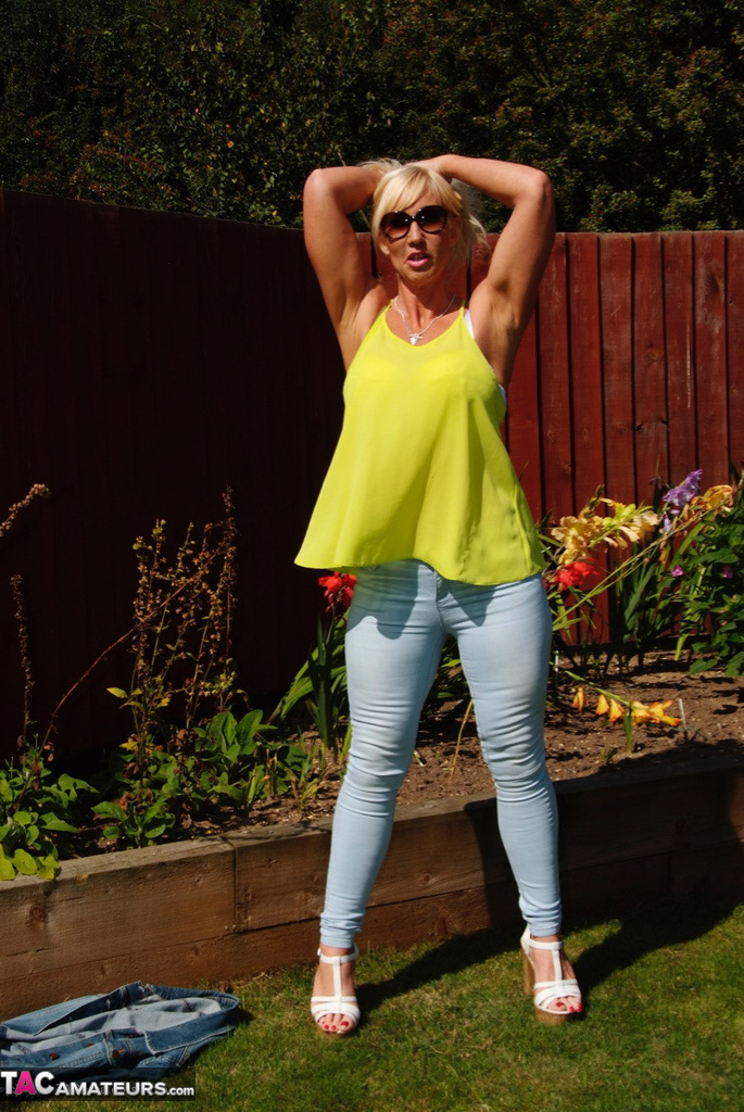 Middle-aged blonde Melody models in a bra and faded jeans in a backyard foto porno #428537067
